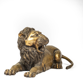 A patinated bronze reclining lion, 20th C.