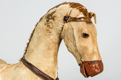 A wooden rocking horse covered with natural fur, early 20th C.