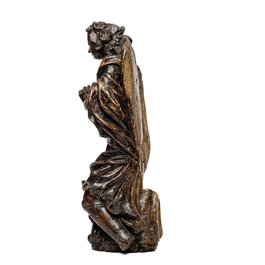A carved oak figure of a kneeling and praying angel with traces of polychromy, 17th C.