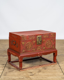 A Chinese red lacquered bronze-mounted travel trunk on foot, 20th C.