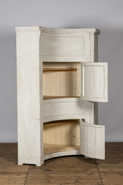 A neoclassical whitewashed corner cabinet, 19th C.