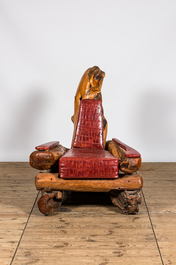 A fauteuil composed of tree trunk fragments with faux-crocodile leather upholstery, 20th C.