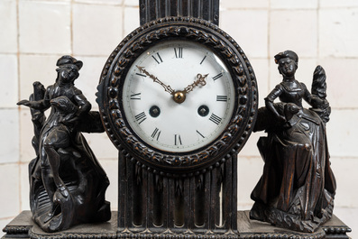 An ebonised mantel clock with romantic figures and topped with a putto, 19th C.