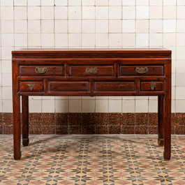 A Chinese wooden side table with drawers, 20th C.