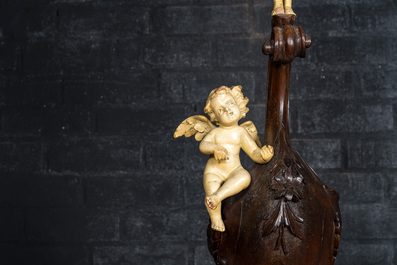 A richly carved walnut jardini&egrave;re or stand with angels, 19th C.