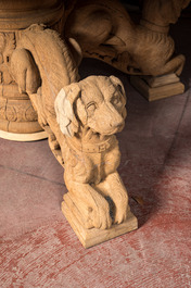 A bleached oak wooden oval table on a richly carved central base with dogs, 19th C.