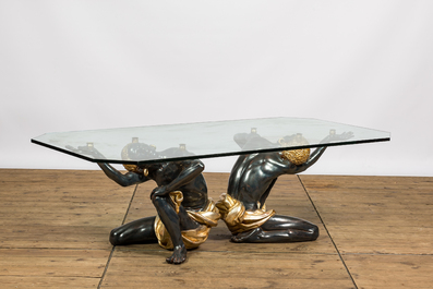 A coffee table with a glass top resting on two polyester Moorish figures, Italy, 2nd half 20th C.