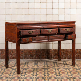 A Chinese wooden side table with drawers, 20th C.