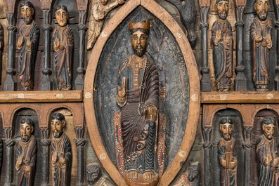 A Spanish polychrome wooden panel depicting Jesus in a medallion surrounded by the twelve apostles after the altar of Sant Pere in Ripoll, 19th C.