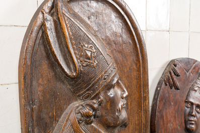 Twee ovale houten reli&euml;fmedaillons met een bisschop en de annunciatie, 17/18e eeuw