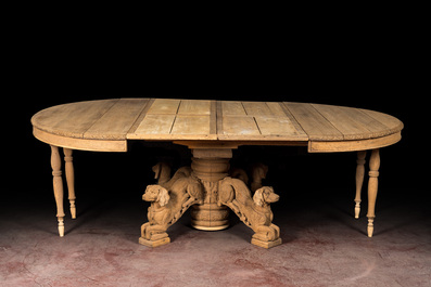 A bleached oak wooden oval table on a richly carved central base with dogs, 19th C.