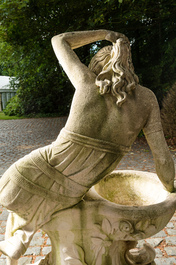 A white painted concrete garden urn flanked by the goddess Flora on matching stand, 20th C.