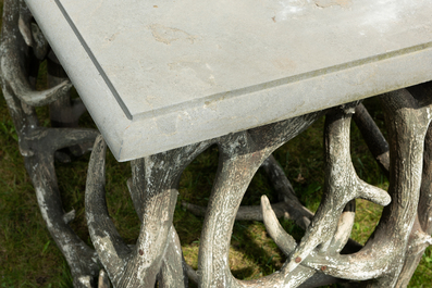 An impressive exterior table with bluestone top on entwined polyester antlers, 20th C.