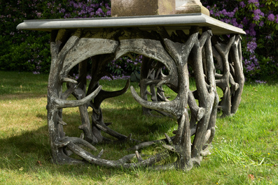 An impressive exterior table with bluestone top on entwined polyester antlers, 20th C.