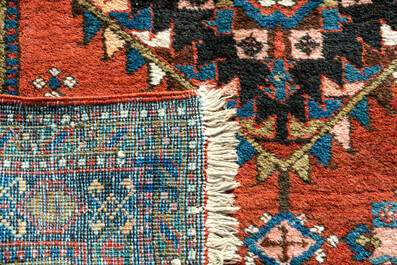 A long Oriental woolen runner with geometric motifs and floral design, 20th C.