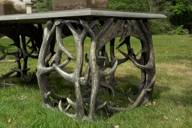 An impressive exterior table with bluestone top on entwined polyester antlers, 20th C.