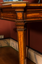 An inlaid wooden Empire-style table with brass mounts on the legs, probably France, 19th C.