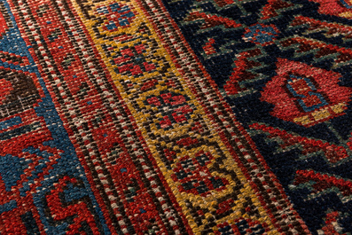 An Oriental rug with geometric motifs and floral design, wool on cotton, 20th C.