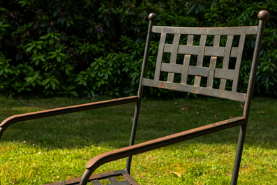 A wrought iron table with slate and wooden top with six chairs, 20th C.