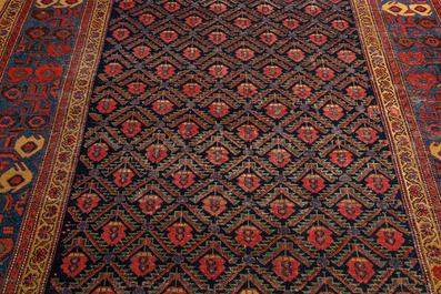 An Oriental rug with geometric motifs and floral design, wool on cotton, 20th C.