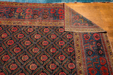 An Oriental rug with geometric motifs and floral design, wool on cotton, 20th C.