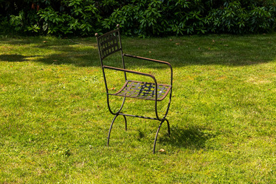 A wrought iron table with slate and wooden top with six chairs, 20th C.