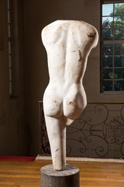 A white marble sculpture of a female torso on a 'petit granit' or Belgian blue stone base, 20th C.