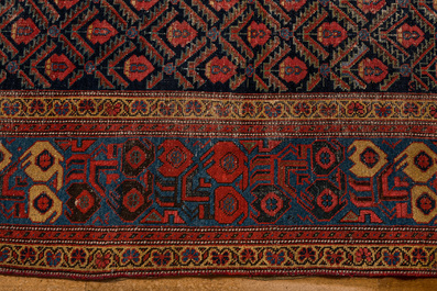 An Oriental rug with geometric motifs and floral design, wool on cotton, 20th C.