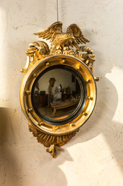 A gilt wooden eagle-topped butler mirror with ebonised border, ca. 1900
