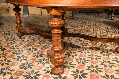 A large oval wooden table on carved baluster-shaped legs, early 20th C.