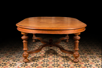 A large oval wooden table on carved baluster-shaped legs, early 20th C.