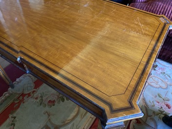 An inlaid wooden Empire-style table with brass mounts on the legs, probably France, 19th C.