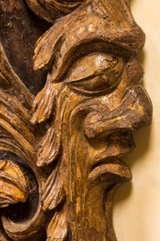 A pair of large gilt wooden reliefs of column fragments with mascarons, 17th C.