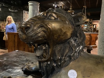 A patinated bronze reclining lion, 20th C.