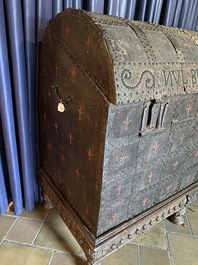 A large French wooden 'bahut' trunk with leather upholstery and wrought iron fittings on a wooden base, dated 1599 but possibly later