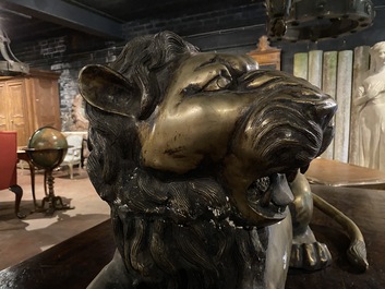 A patinated bronze reclining lion, 20th C.