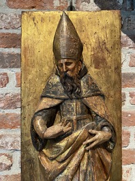 A pair of polychrome wooden reliefs with Saint Anthony and a bishop, 17th C.