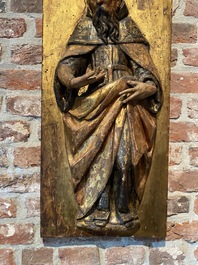 A pair of polychrome wooden reliefs with Saint Anthony and a bishop, 17th C.