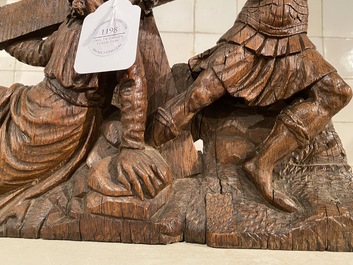 A Flemish carved oak retable fragment depicting the 'Road to Calvary with Saint Veronica', 16th C.