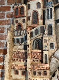 A large polychrome 'Jerusalem' relief on a winged cherub console, 19th C.