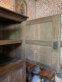 A rare large Flemish oak four-door cupboard with carved X-panels and wrought iron mounts, 1st half 16th C.