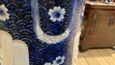 A large blue and white Arita porcelain cylindrical vase or umbrella stand with molded design, Japan, Meiji, 19th C.