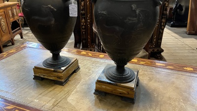 A pair of neoclassical style vases with charioteers on a Siena marble base, 19/20th C.