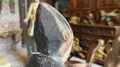 A Flemish carved and polychromed oak figure of a bishop on an armorial base, ca. 1500