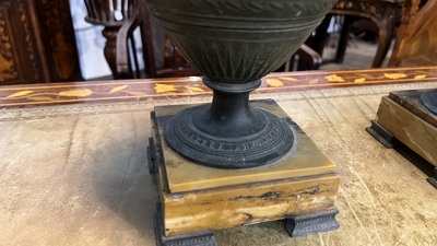 A pair of neoclassical style vases with charioteers on a Siena marble base, 19/20th C.