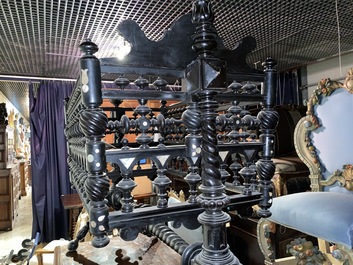 An attractive ebony-inlaid ebonised wooden cradle, 19th C.