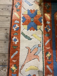 An Oriental woolen rug with floral design and geometric motifs, 20th C.