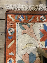 An Oriental woolen rug with floral design and geometric motifs, 20th C.