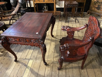 A finely carved Japanese red patinated wooden desk with armchair, 20th C.