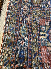 A long Oriental woolen runner with geometric motifs and floral design, 20th C.